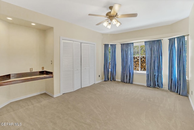 unfurnished bedroom with ceiling fan, a closet, and light colored carpet