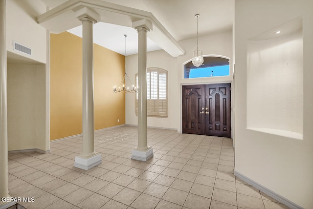 entryway with light tile patterned flooring, a notable chandelier, and a high ceiling