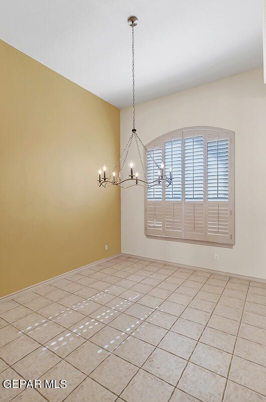 unfurnished dining area with light tile patterned flooring and a chandelier