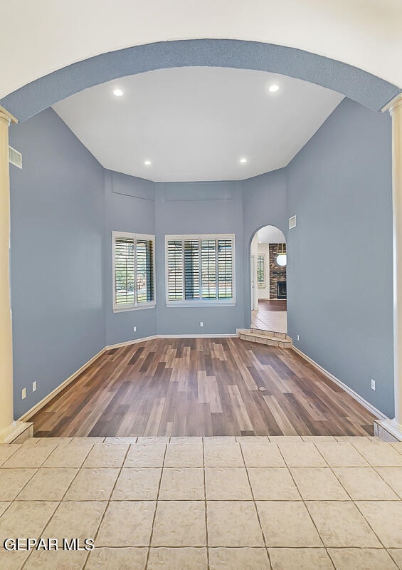 unfurnished living room featuring ornate columns and light hardwood / wood-style floors