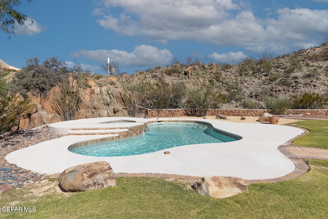 view of swimming pool with an in ground hot tub, a yard, and a patio area