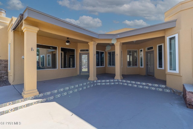 rear view of property with ceiling fan and a patio