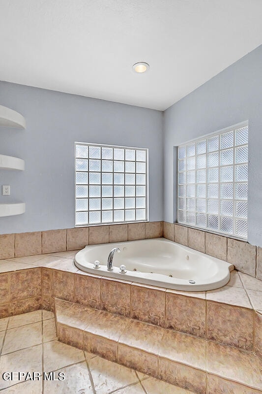 bathroom featuring tiled tub and tile patterned floors