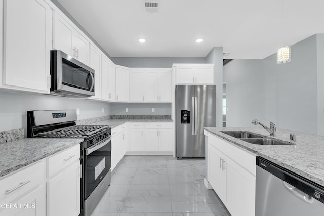 kitchen with white cabinetry, stainless steel appliances, sink, and hanging light fixtures