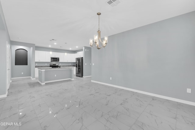 kitchen featuring appliances with stainless steel finishes, white cabinets, a chandelier, hanging light fixtures, and a center island