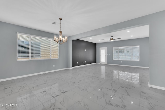 unfurnished room featuring ceiling fan with notable chandelier