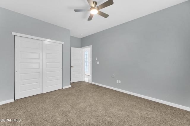 unfurnished bedroom with ceiling fan, carpet flooring, and a closet