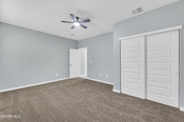 unfurnished bedroom featuring dark carpet, a closet, and ceiling fan