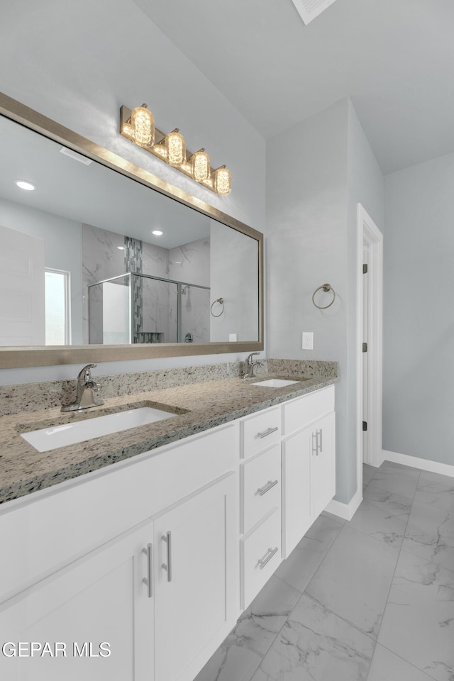 bathroom featuring a shower with door and vanity