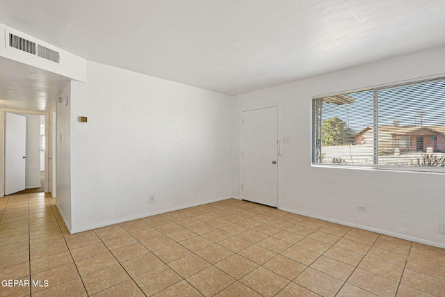 spare room featuring visible vents and light tile patterned floors