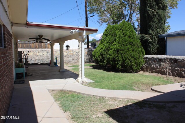 view of yard with a patio area and ceiling fan