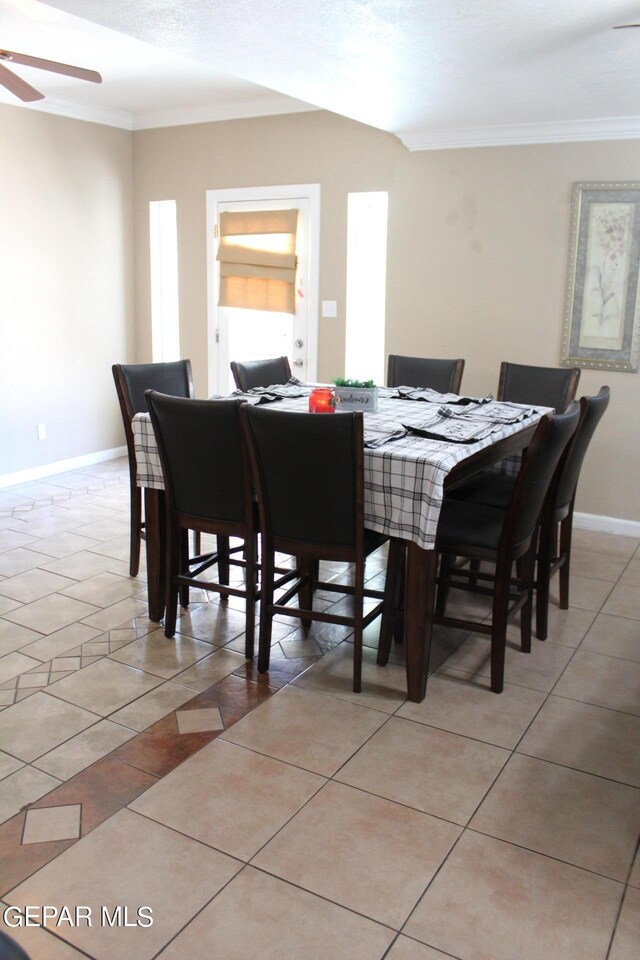 dining space featuring crown molding, light tile patterned floors, and ceiling fan