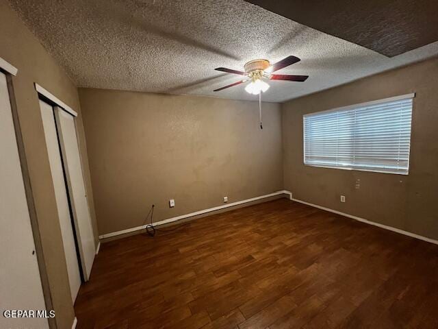 unfurnished bedroom featuring dark wood-type flooring, ceiling fan, and a textured ceiling