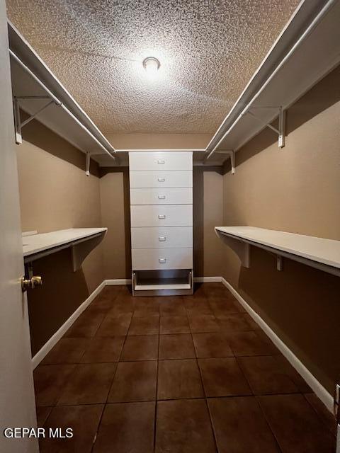 walk in closet featuring dark tile patterned floors