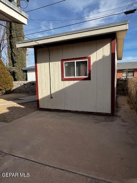 view of side of property with a shed and a patio