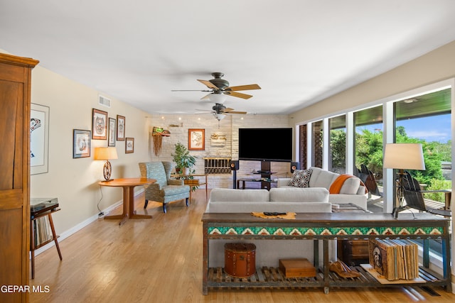 living room featuring light hardwood / wood-style floors, brick wall, and ceiling fan