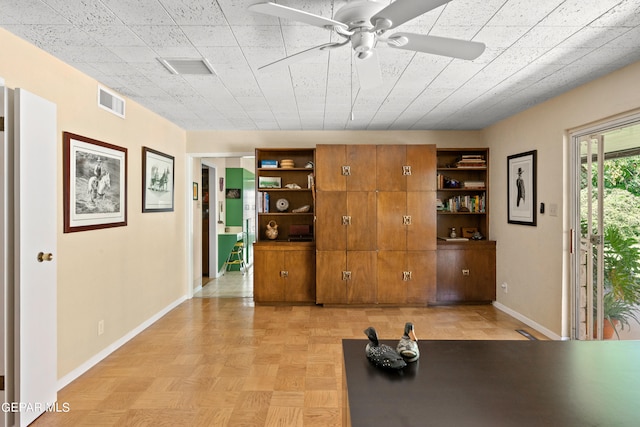 exercise area featuring ceiling fan and light parquet floors