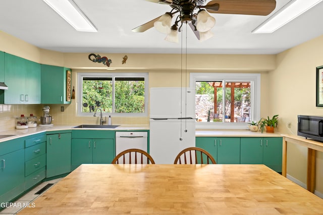 kitchen with a wealth of natural light, sink, green cabinets, white appliances, and ceiling fan