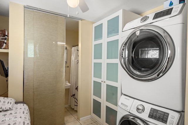 laundry area with ceiling fan, light tile patterned floors, and stacked washing maching and dryer