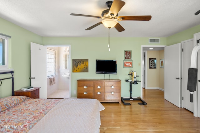 bedroom featuring multiple windows, light hardwood / wood-style floors, and ensuite bathroom