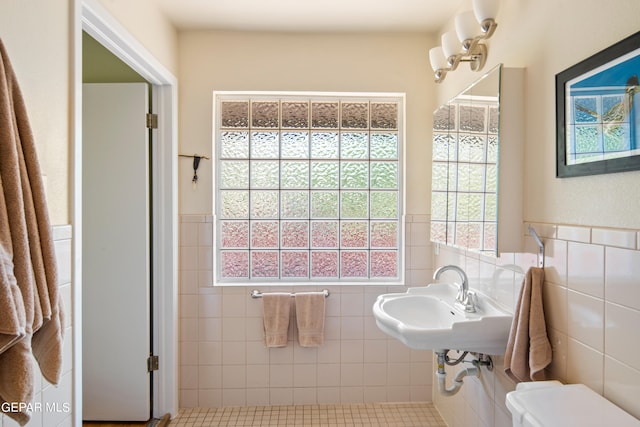 bathroom featuring tile walls, toilet, and tile patterned floors