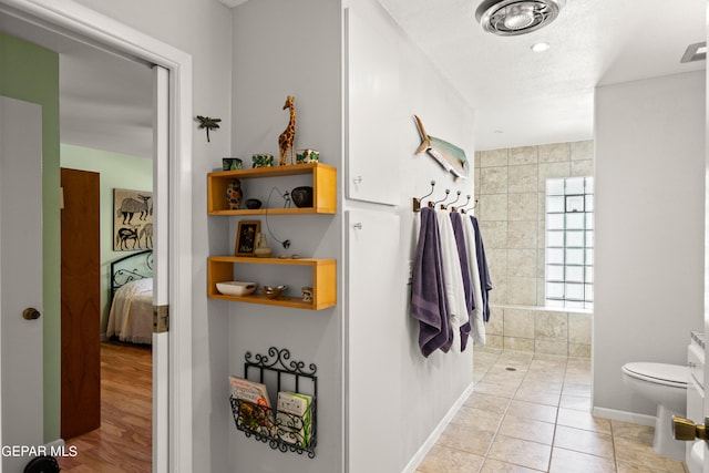 bathroom featuring a textured ceiling, toilet, and tile patterned floors