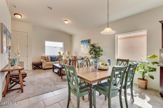 dining room featuring vaulted ceiling and light tile patterned floors