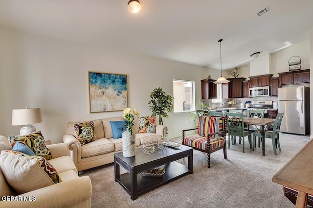 living room featuring light colored carpet and vaulted ceiling