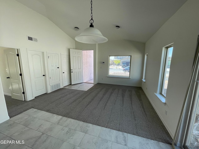 carpeted spare room featuring high vaulted ceiling