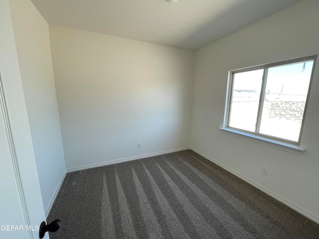 unfurnished room with dark colored carpet