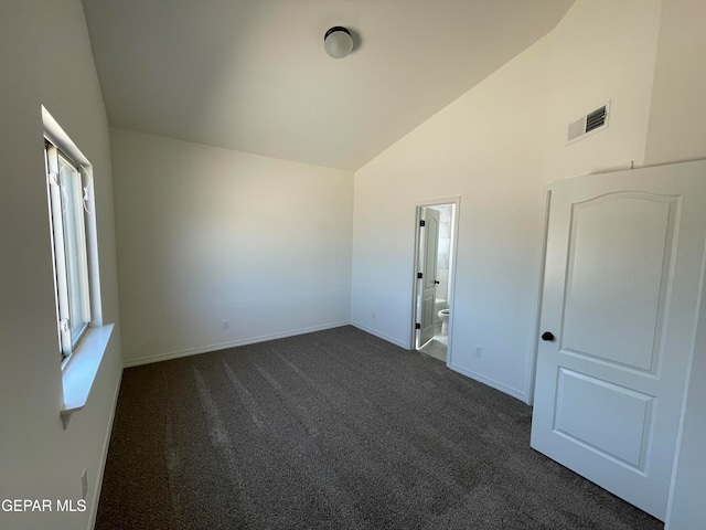 carpeted spare room featuring lofted ceiling