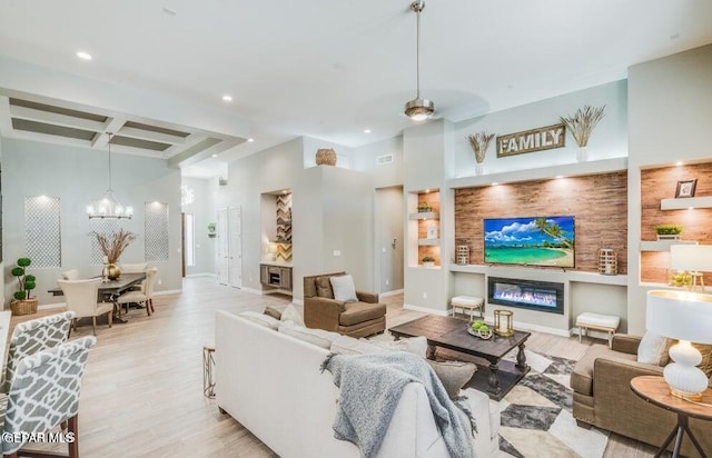 living room featuring ceiling fan with notable chandelier, beam ceiling, coffered ceiling, and light hardwood / wood-style flooring