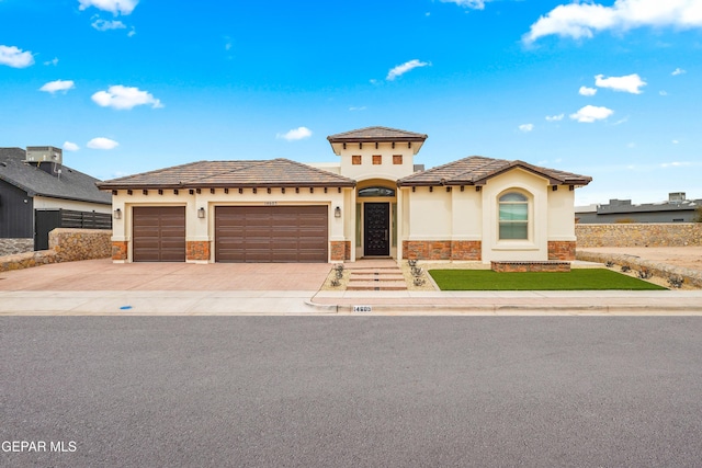 mediterranean / spanish-style house with a garage, stone siding, driveway, and stucco siding