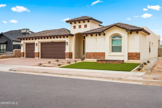 mediterranean / spanish-style home with stucco siding, stone siding, driveway, and an attached garage