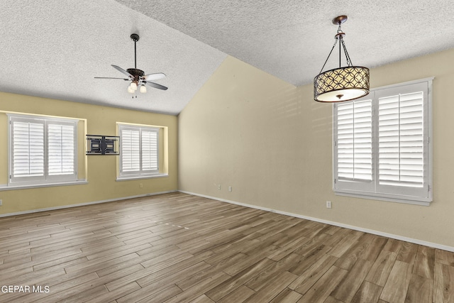 unfurnished room featuring a textured ceiling, lofted ceiling, ceiling fan, and hardwood / wood-style flooring