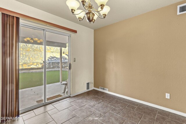 unfurnished room featuring a chandelier