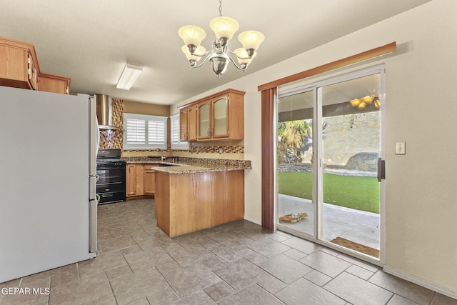 kitchen with black gas range oven, white fridge, backsplash, decorative light fixtures, and light stone countertops