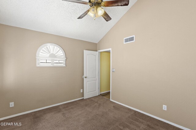 empty room with a textured ceiling, carpet flooring, vaulted ceiling, and ceiling fan