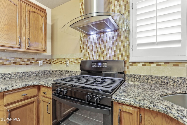 kitchen featuring range hood, light stone counters, a textured ceiling, and black range with gas stovetop