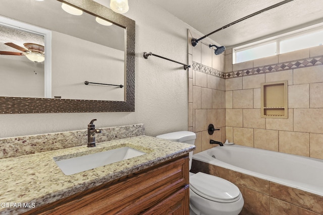 full bathroom featuring a textured ceiling, tiled shower / bath combo, ceiling fan, vanity, and toilet