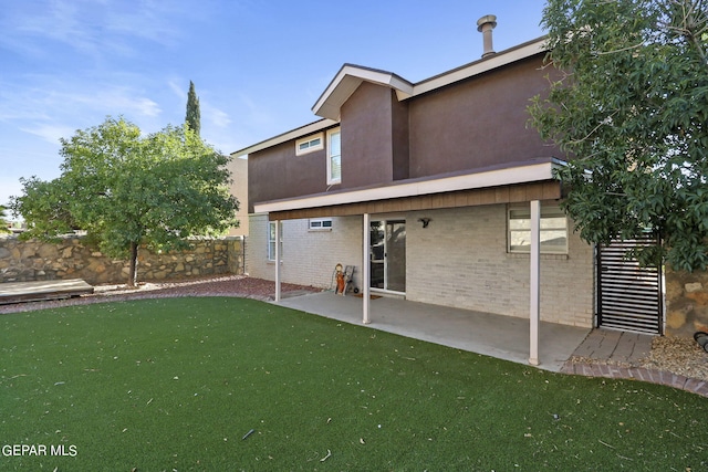 rear view of property featuring a lawn and a patio area