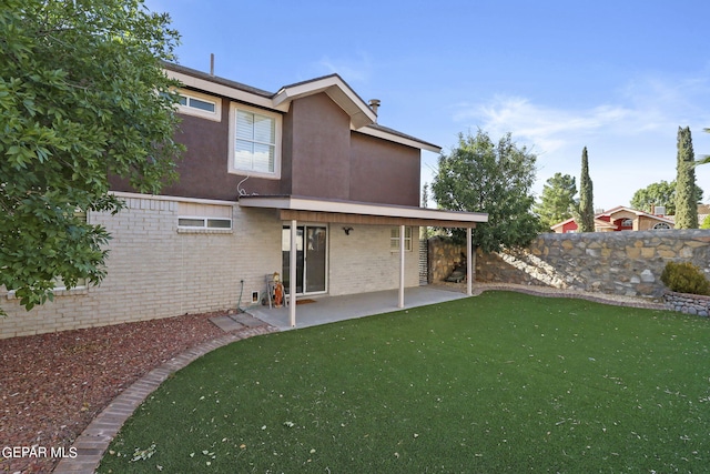 rear view of house featuring a patio and a yard