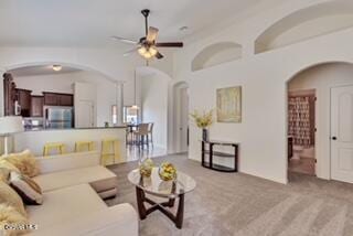 carpeted living room with ceiling fan