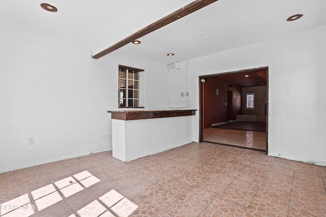 unfurnished living room with beamed ceiling