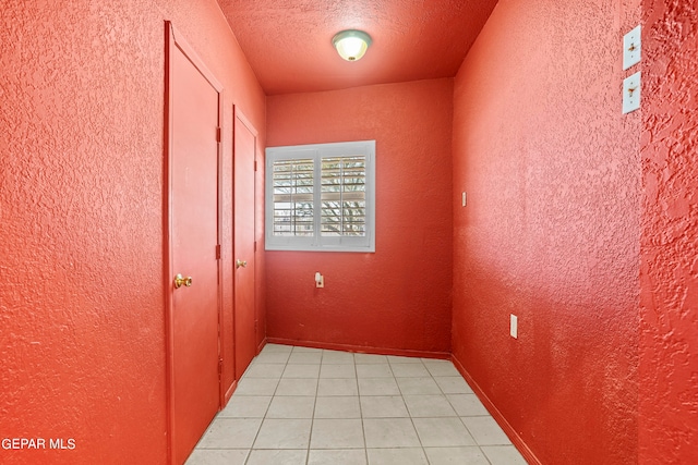 tiled spare room featuring a textured ceiling