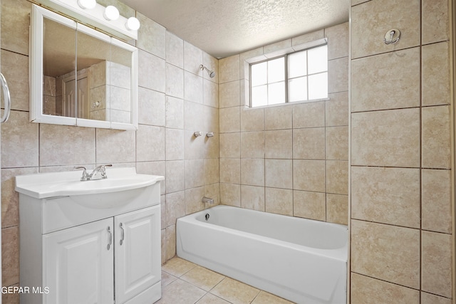 bathroom featuring tile patterned floors, tile walls, tiled shower / bath combo, vanity, and a textured ceiling