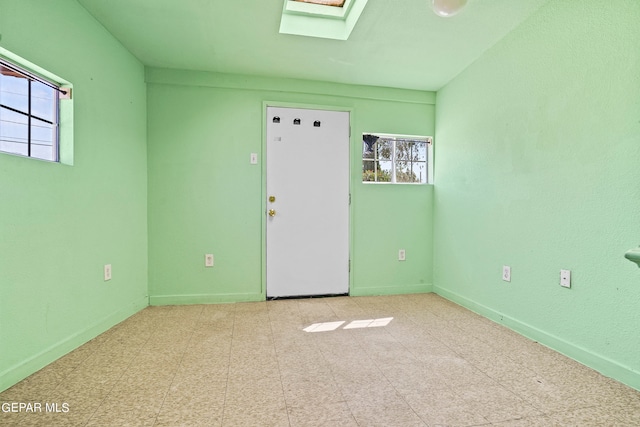 unfurnished room featuring a skylight and a wealth of natural light