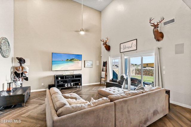 living room featuring parquet flooring and high vaulted ceiling