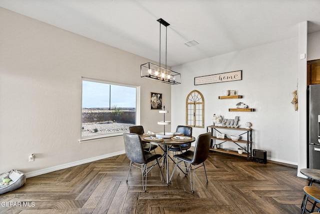 dining room with a chandelier and dark parquet flooring