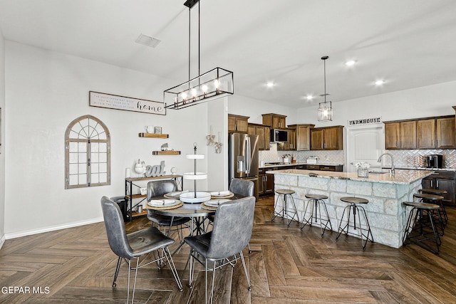 dining area featuring a chandelier, dark parquet floors, and sink